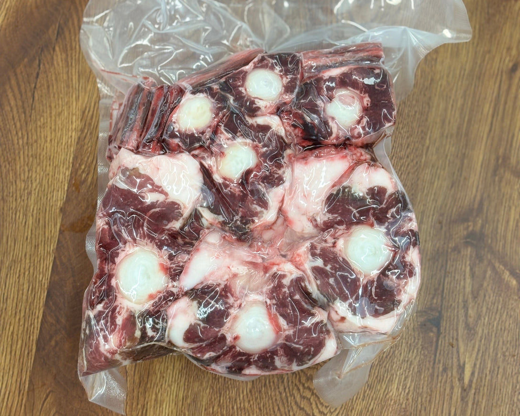 Vacuum-sealed package of raw beef on a wooden surface