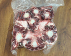 Vacuum-sealed package of raw beef on a wooden surface