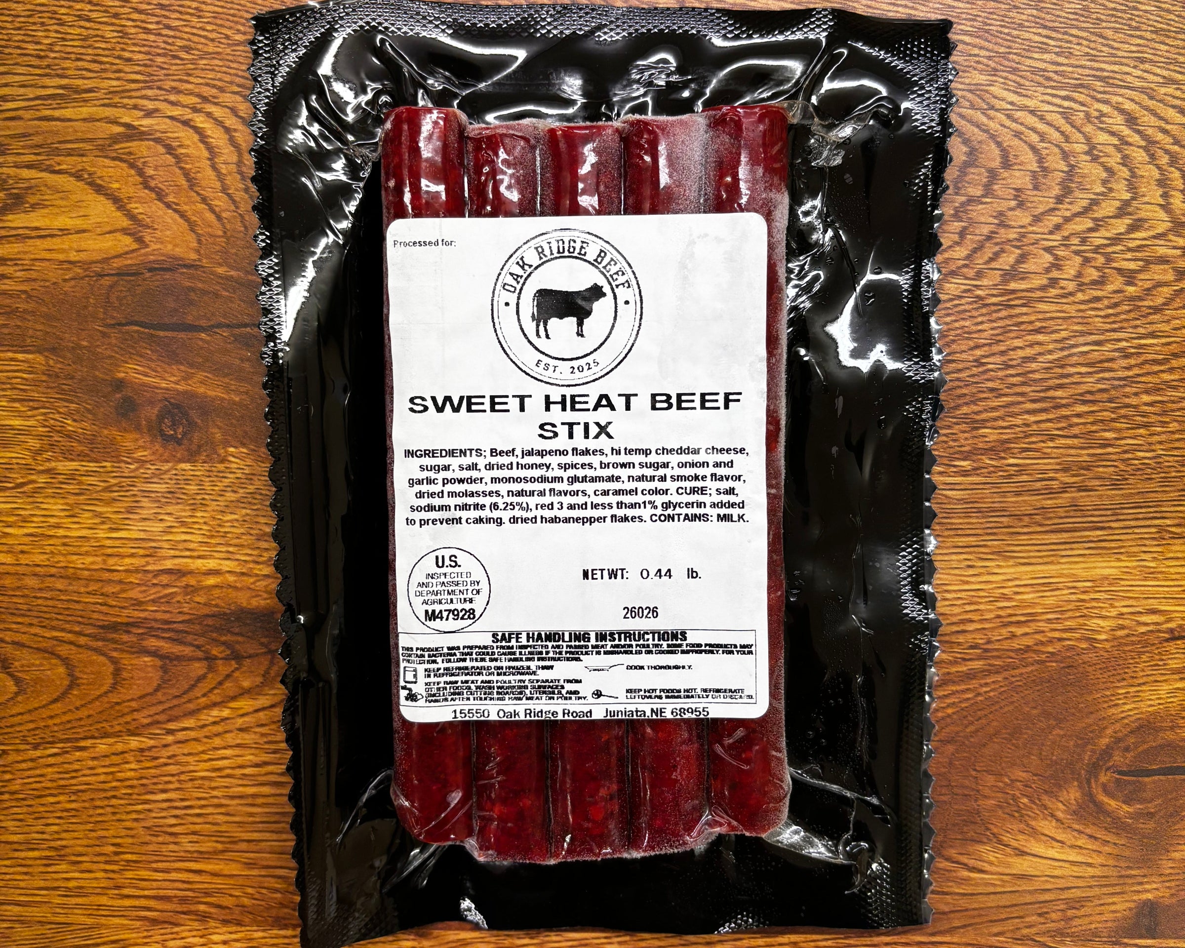 Packaged beef sticks with a label on a wooden surface