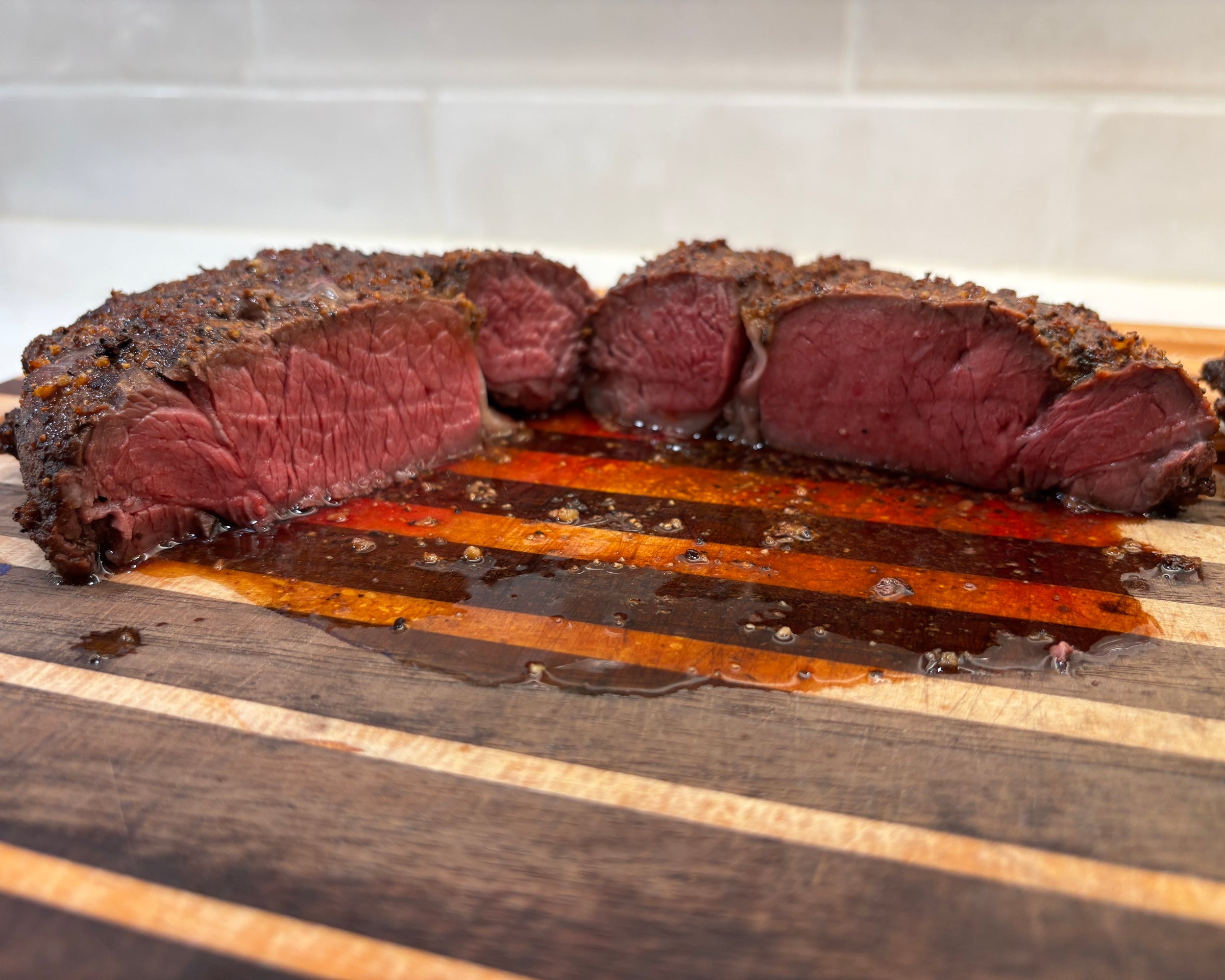 Sliced beef on a wooden cutting board with a white background