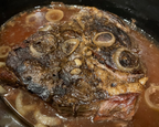 Slow cooker with braised roast and onions in a rich sauce