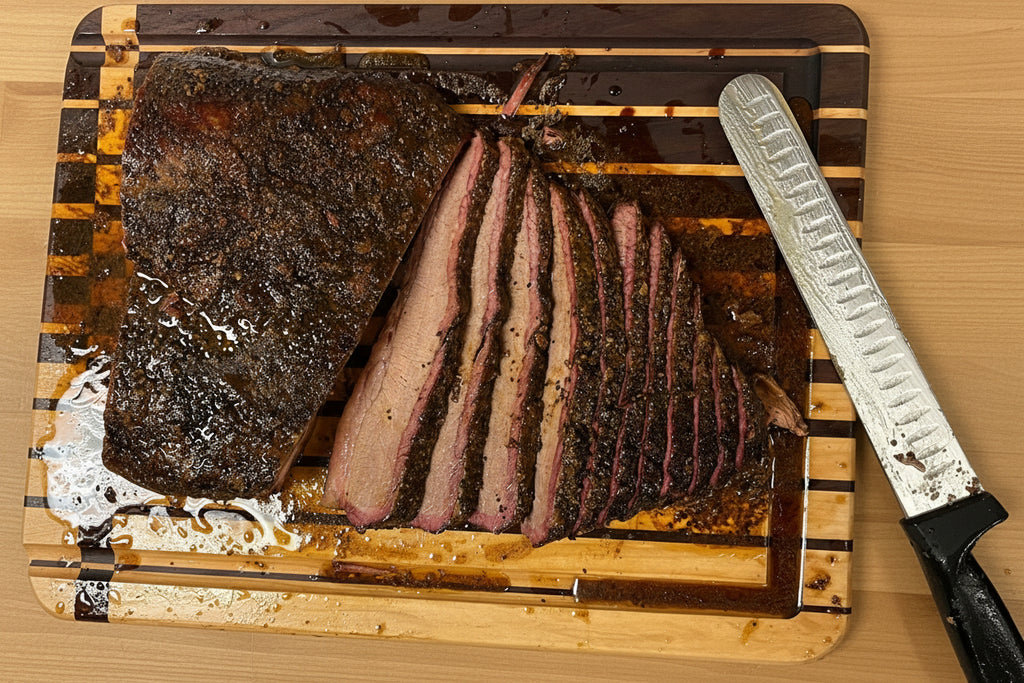 Sliced brisket on a wooden cutting board with a knife next to it.